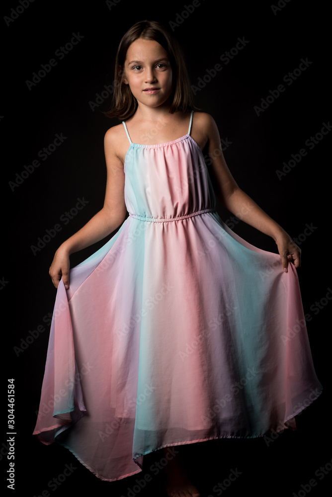 Portrait of happy young little girl holding long colourful dress. Portrait of happy young little girl holding long colourful dress.