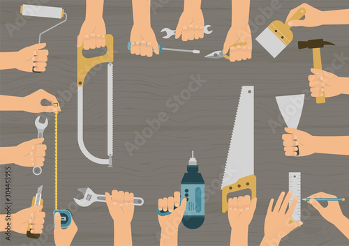 Realistic hands holding several construction, repair and DIY hand tools set on wood table background