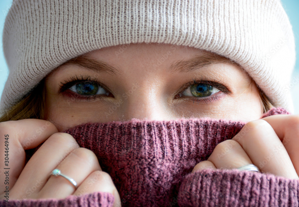 Close up of a woman's covered face with winter hat and warm sweater. Only her eyes are visible. Close up of a woman's covered face with winter hat and warm sweater. Only her eyes are visible.