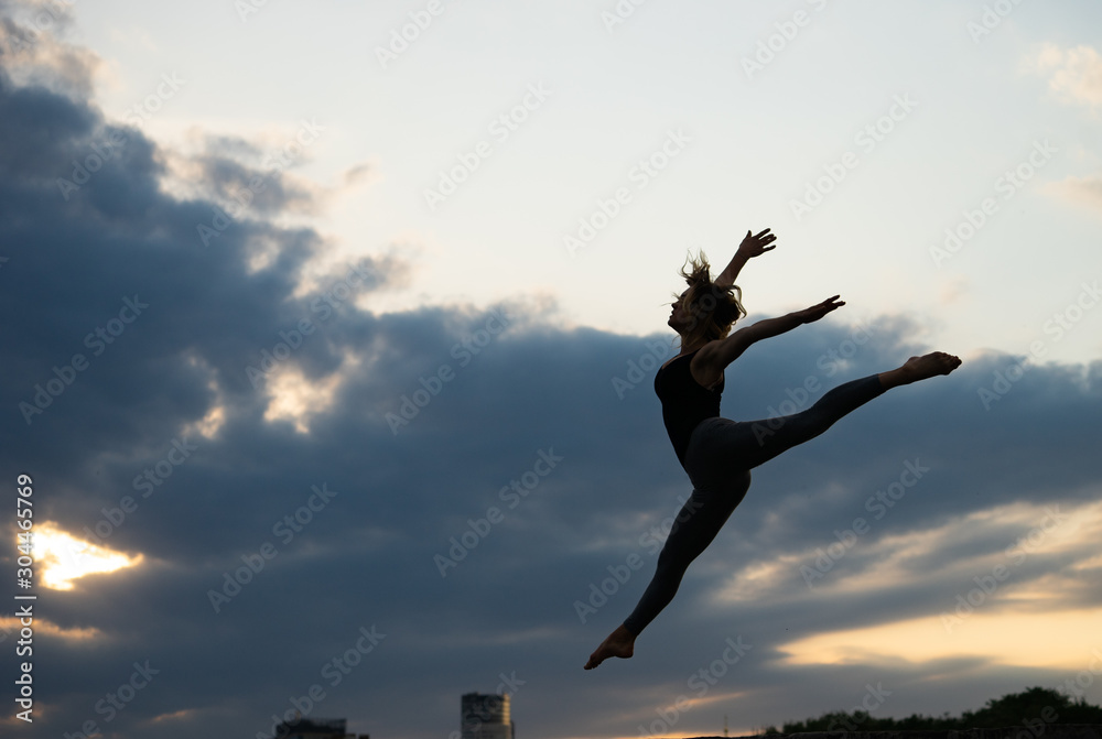 Young woman dancer on outdoor sunrise background. Concept of freedom and happy lifestyle