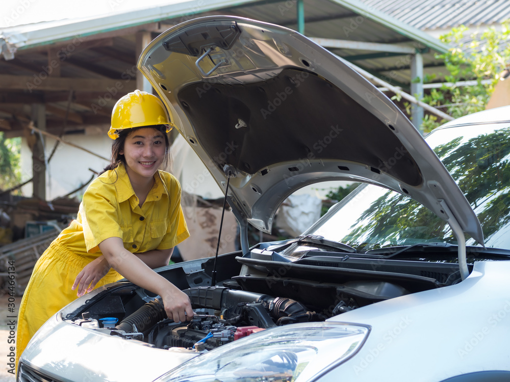 The woman in the mechanic's work set is using a wrench to open the parts of the engine The woman in the mechanic's work set is using a wrench to open the parts of the engine