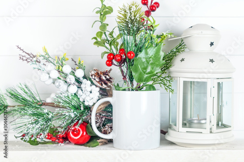 Mug mockup with fir branches, cones and Christmas lantern