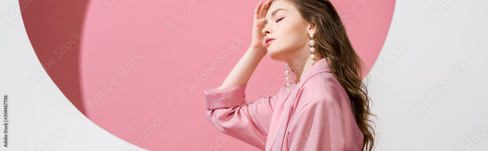 panoramic shot of beautiful girl touching hair on white and pink - obrazy, fototapety, plakaty 
