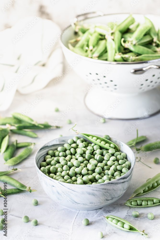 Green baby peas in pan on white background. copy space Green baby peas in pan on white background. copy space