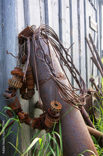 rusty scrap metal lies in tall grass