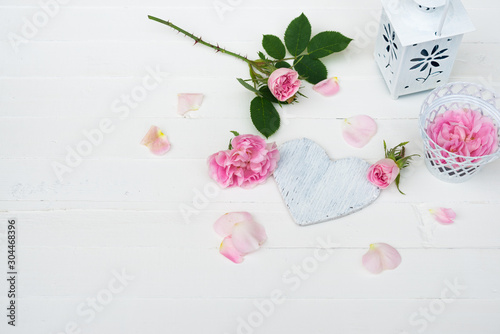 Pink Roses Flowers, Rose Petals, Wooden Heart on White Wooden table. Happy Valentine's Day, Mother's Day, Women's day, Wedding, Happy Birthday, Love Background