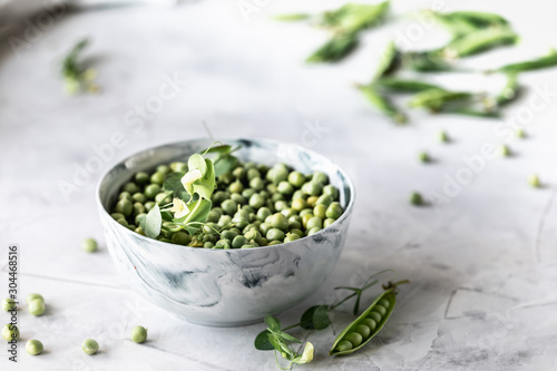 Green baby peas in pan on white background. copy space