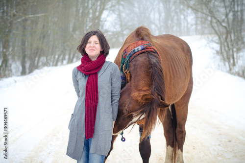 portrait of girl and red trakehner stallion horse with scarf in winter