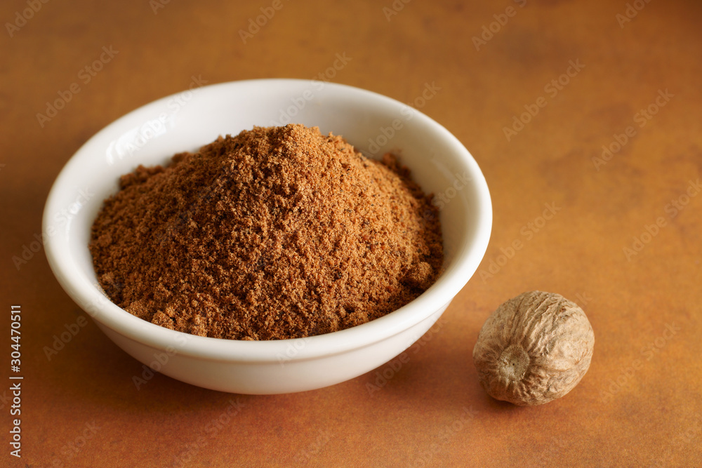 Whole and ground nutmeg a fragrant spice from the fruit of tree Myristica fragrans Whole and ground nutmeg a fragrant spice from the fruit of tree Myristica fragrans