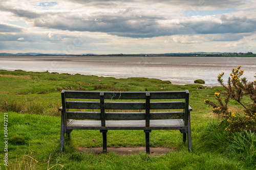 A bench at the Solway coast, looking at the Channel of River Esk in Bowness-on-Solway, Cumbria, England, UK