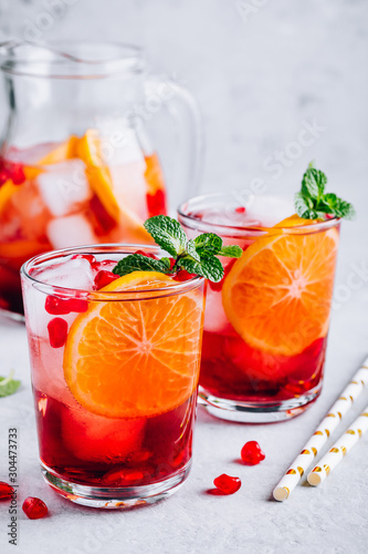 Pomegranate Orange Holiday Punch with ice and mint in glass