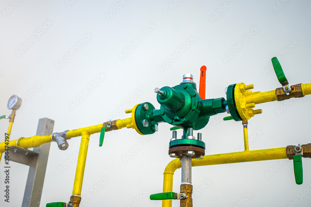 High pressure regulator valve in pipeline gas. Gas pipeline system, Yellow gas pipe in front of residential building wall.