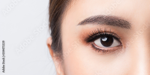 Asian female Eye with Extreme Long False Eyelashes. Eyelash Extensions. Makeup, Cosmetics, Close up macro eye woman. photo