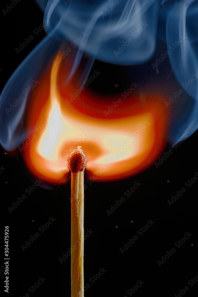 Safety match on black background with flaming head Safety match on black background with flaming head