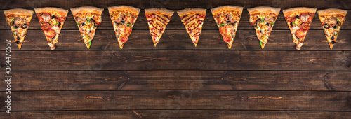 slices of tasty pepperoni pizza looking like christmas flags, creative holiday banner and concept of fast food on wooden background with copy space, top view