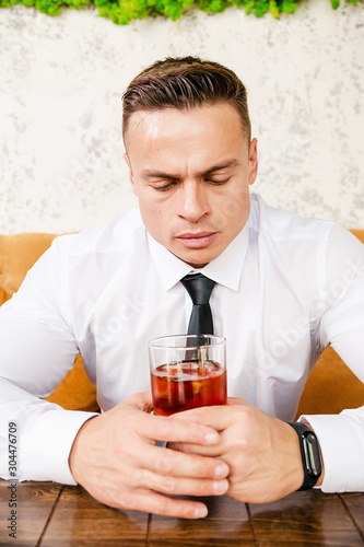 Businessman drinks whiskey at the table