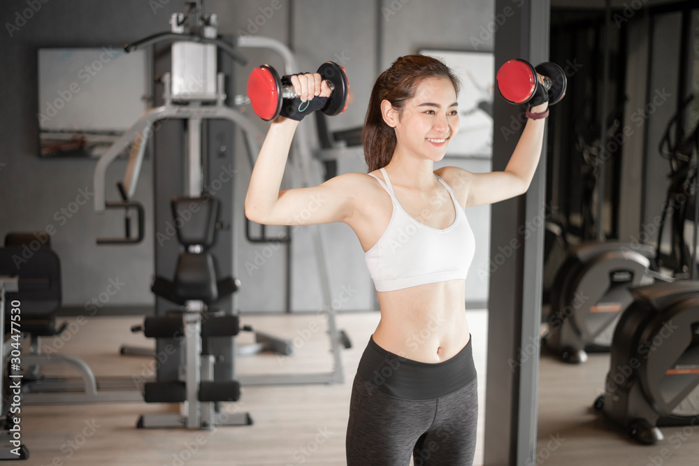 Beautiful asian woman is doing exercise in the gym Beautiful asian woman is doing exercise in the gym