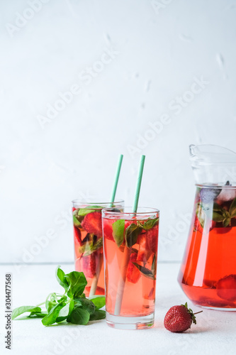 Homemade fresh strawberry lemonade with basil leaves on a light background copy space.