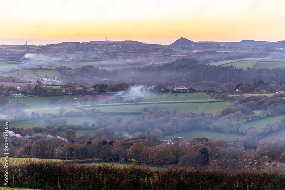 The haze of wood smoke over a Cornish valley in autumn