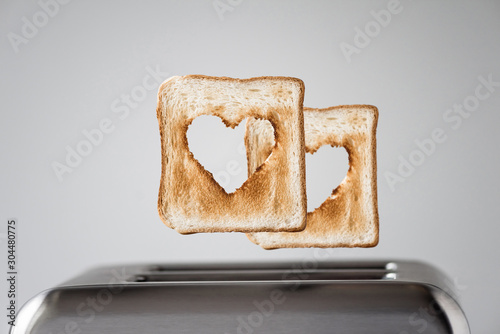 Two Heart shaped on roasted toasted bread in a toaster. Breakfast preparation on Valentine's Day. symbol sign of love. Concept