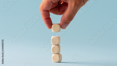 Stacking four blank wooden dices