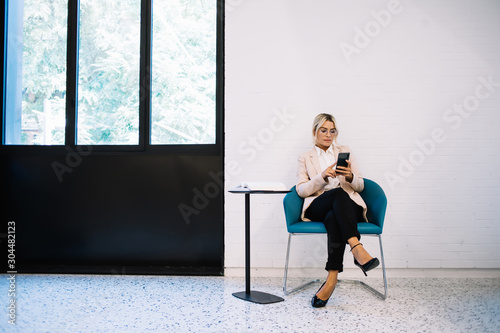 Young female professional reading received message with notification for application on smartphone device  smart woman manager writing email answer to boss of company connected to 4g internet