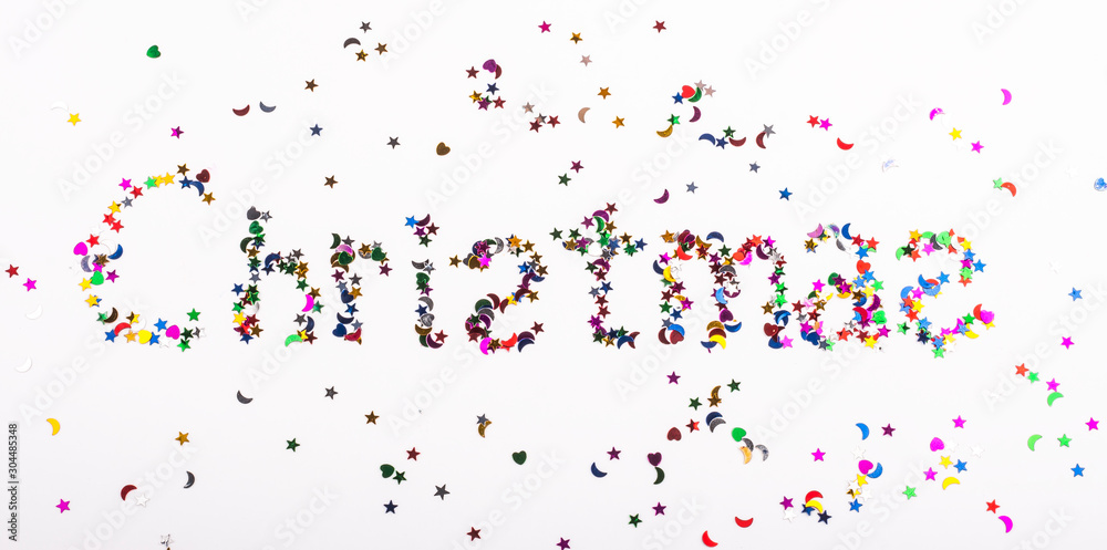 the word Christmas is written in sequins on a white background the word Christmas is written in sequins on a white background