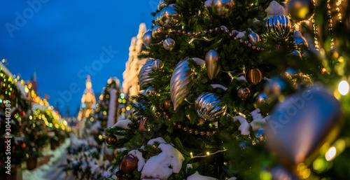 Decorated Christmas tree on blurred background. Festive street lights.