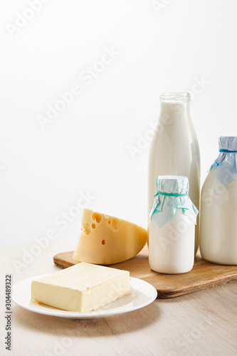 various fresh organic dairy products on wooden board isolated on white