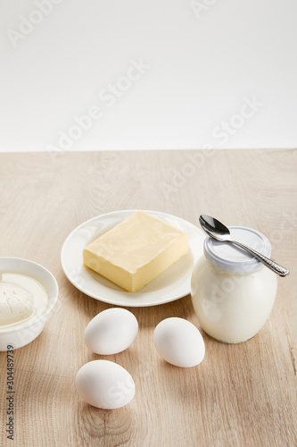 delicious organic dairy products and eggs on wooden table isolated on white