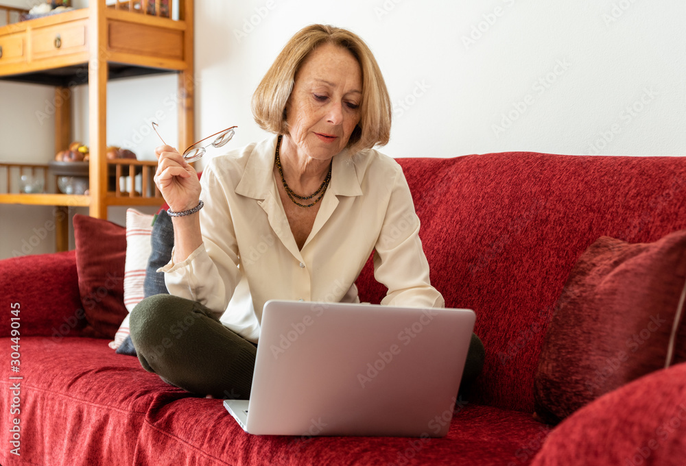 Fototapeta premium Elegant mature woman using computer at home