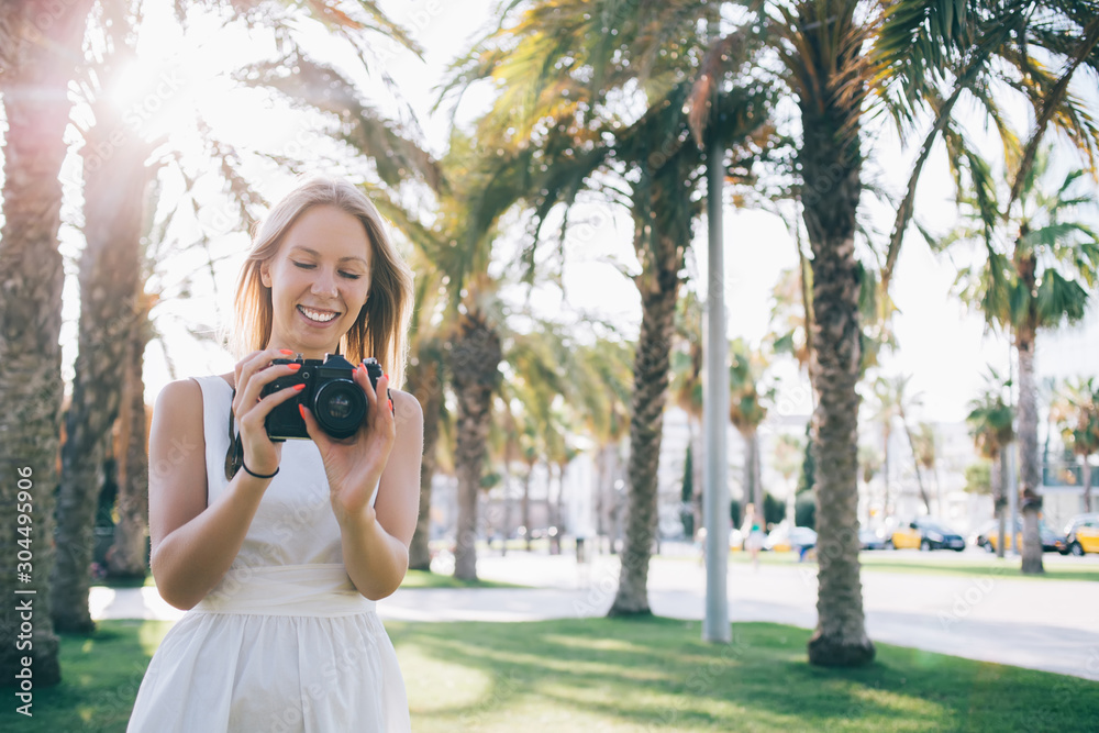Smiling woman picturing with camera in sunshine Smiling woman picturing with camera in sunshine