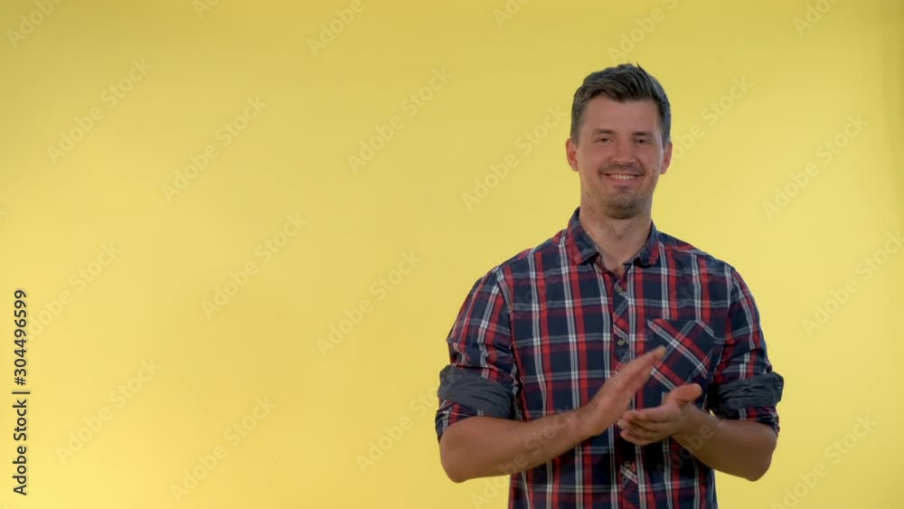 Portrait of smiling young man giving applause to somebody on yellow background. He clapping his hands. Portrait of smiling young man giving applause to somebody on yellow background. He clapping his hands.