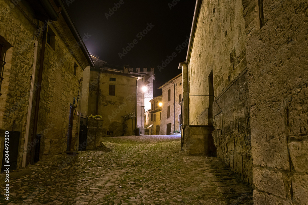 Narrow street at night in the village of Vigoleno in Italy
