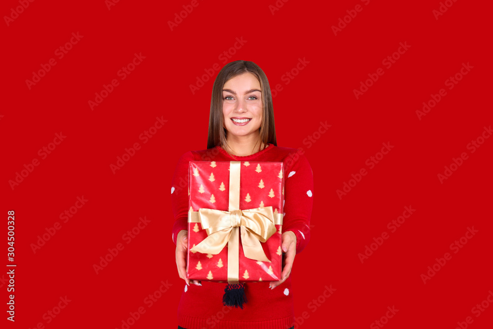 Beautiful smiling young woman wearing knitted sweater celebrating Christmas. Attractive brunette female, new years eve. Gift shopping concept. Copy space background, close up portrait, isolated