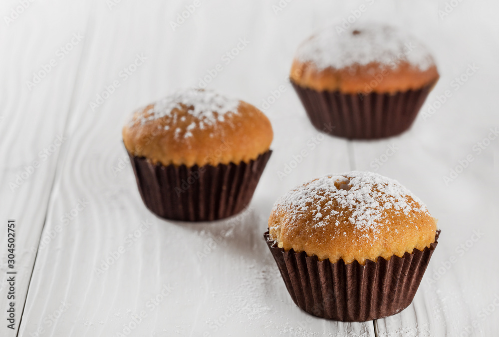 Tasty cupcake with icing sugar on a wooden table. Tasty cupcake with icing sugar on a wooden table.