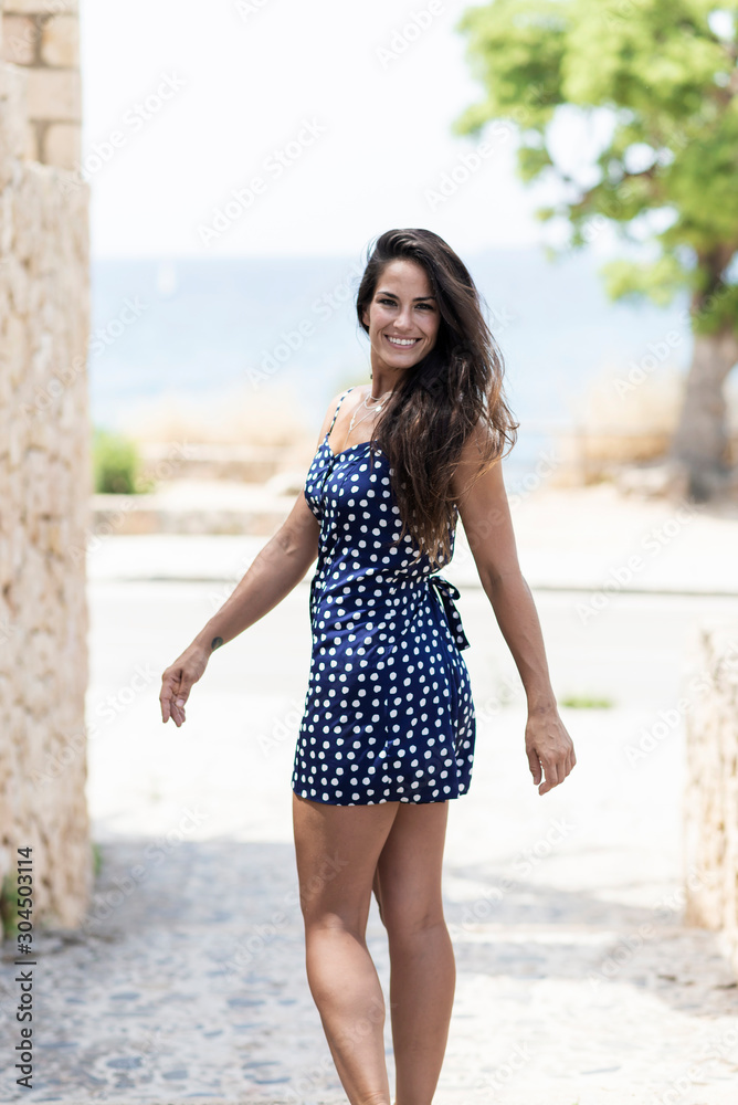 Beautiful hispanic woman in blue dress standing outdoors while looking camera Beautiful hispanic woman in blue dress standing outdoors while looking camera