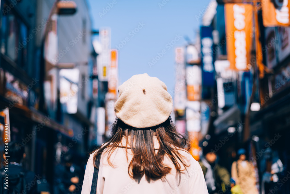 Asian girl standing out from the crowd at a city street in Japan.