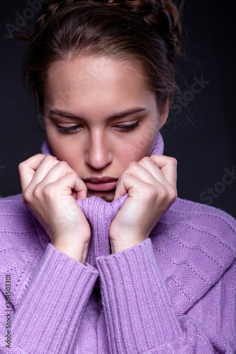 Portrait of a beautiful girl in a lilac sweater.
