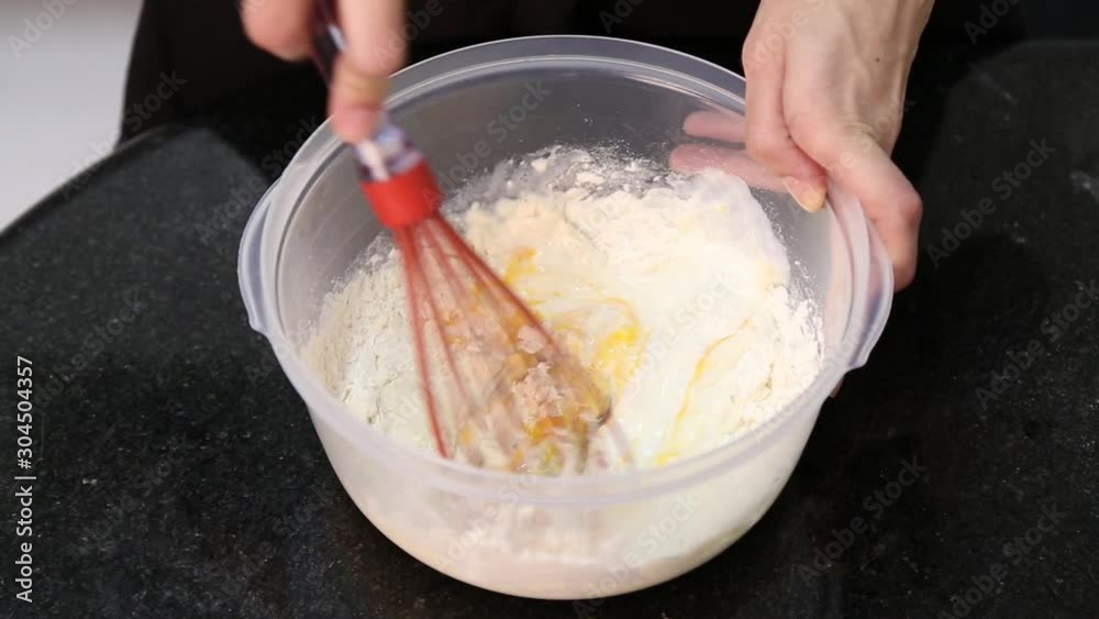 Woman cooking with fue in a bowl preparing dough Woman cooking with fue in a bowl preparing dough