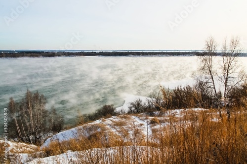 Fototapeta Naklejka Na Ścianę i Meble -  Misty water vapor rises from the water in the river in November