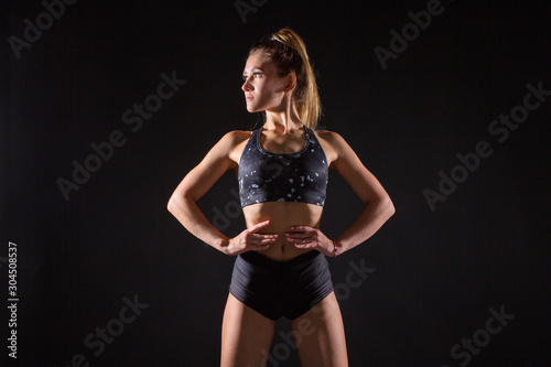 beautiful young woman with an athletic figure on a black background photo