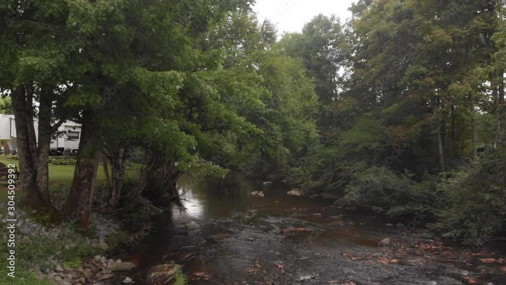 Panning with a drone alone a river to the campgrounds Panning with a drone alone a river to the campgrounds