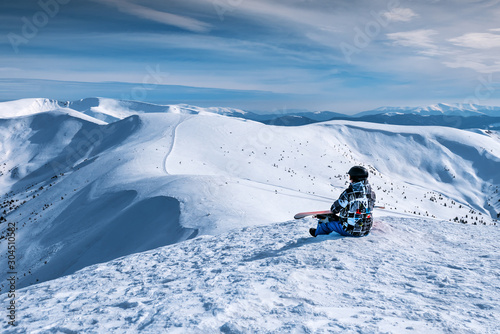 snowboarder sits on a mountainside