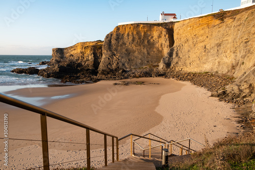 Beach of Zambujeira do Mar and small church on the cliff in Costa Vicentina, Portugal