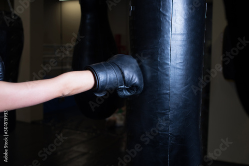 Boxer woman hands with red boxing wraps in dark room. Close-up shot © Konstantin