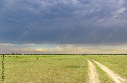 Jeep through the Okavango Delta under stormy cloudy sky