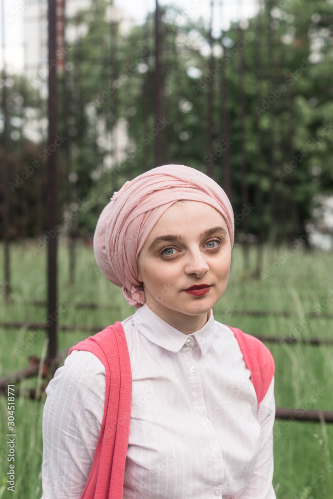 romantic portrait of young European Muslim woman with hijab have fun at beautiful sunny day. Image of pretty woman sitting and posing for camera. She is happy and relaxed. romantic portrait of young European Muslim woman with hijab have fun at beautiful sunny day. Image of pretty woman sitting and posing for camera. She is happy and relaxed.