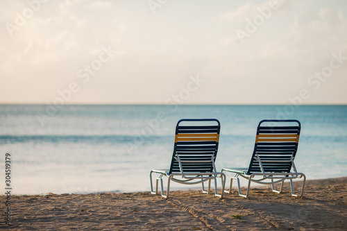 White lounge chairs on a beautiful tropical beach at Maldives