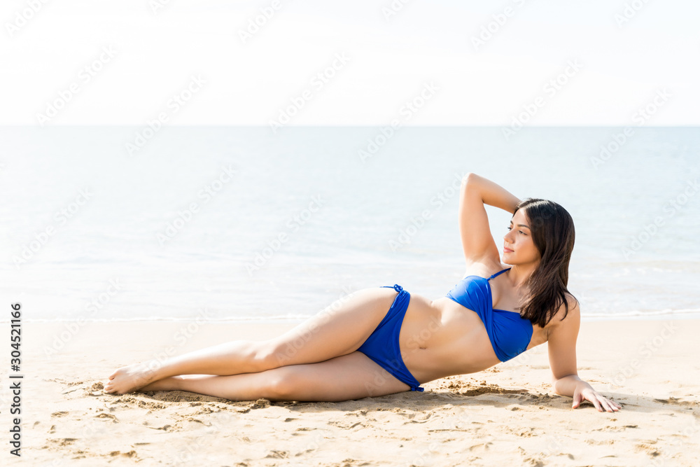 Woman Posing In Bikini Relaxing On Beach